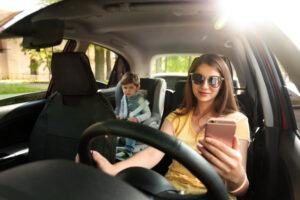 Mother,Using,Phone,While,Driving,Car,With,Her,Son,On