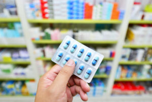 Pharmacist holding medicine capsule pack at the pharmacy drugstore