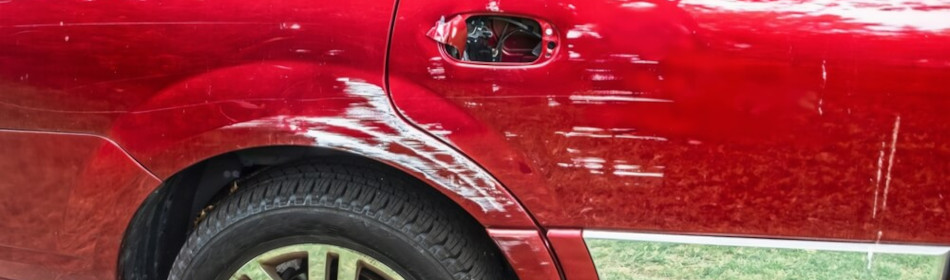 Bright cherry red pickup truck that's been sideswiped by white vehicle.