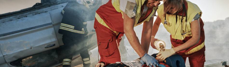 paramedics helping someone severely injured in a traffic accident