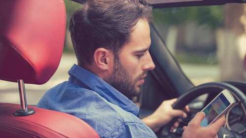 man driving distracted and texting