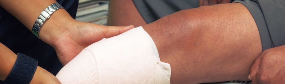 nurse bandaging a patient's knee