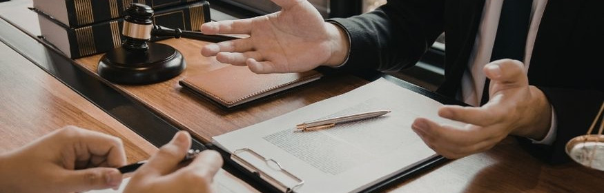 Lawyer and client discuss while signing a document