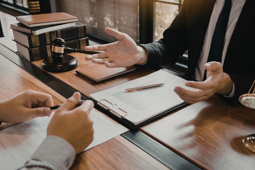 Lawyer and client discuss while signing a document
