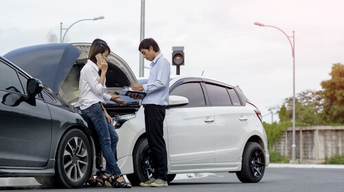 Two passengers exchanging insurance information after an accident.